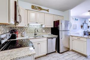 a kitchen with white cabinets and a refrigerator at Fiddlers Cove 18B in Hilton Head Island +39 photos