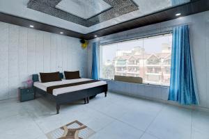 a bedroom with a bed and a large window at Hotel O NICE HOTEL in Faridabad