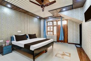 a bedroom with a bed and a ceiling fan at Hotel O NICE HOTEL in Faridabad