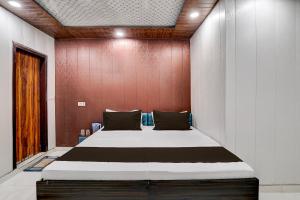 a large bed in a room with a wooden wall at Hotel O NICE HOTEL in Faridabad +21 photos