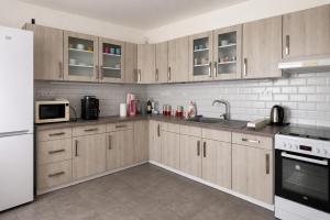 a kitchen with wooden cabinets and a white refrigerator at Penzión Aurora Patince in Patince