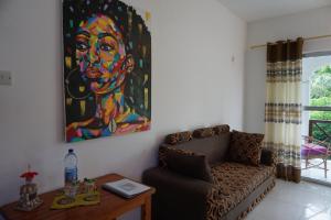 a living room with a painting on the wall and a couch at Cocolala Beach House in Nungwi