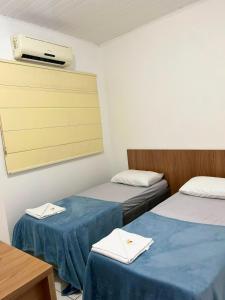 a room with two beds and a air conditioner on the wall at HOTEL ITAPUÃ vg in Várzea Grande +24 photos