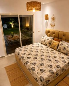 a bedroom with a bed and a view of a patio at Pool View Apartment Gated Residence in Sidi Rahal +23 photos