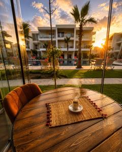 a wooden table with a coffee cup on top of it at Pool View Apartment Gated Residence in Sidi Rahal