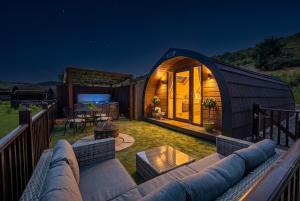 a black igloo house with a couch in a yard at Calmwater Hideaway in New Hey