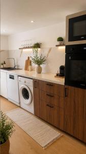 a kitchen with a washing machine and a microwave at House in Obernai in Obernai