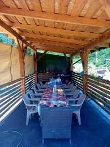 a long table and chairs on a covered deck at DiBosco House in Dubova