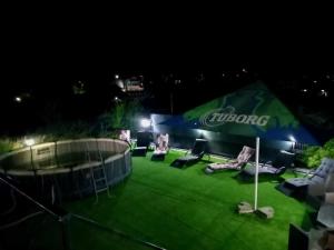 a tent with chairs on a lawn at night at DiBosco House in Dubova