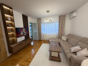 a living room with a couch and a flat screen tv at Stan na dan Hilandarska 9 in Lukavica
