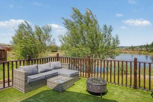 a patio with a couch and a grill on the grass at Calmwater Hideaway in New Hey