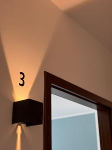 a clock on the wall next to a window at Bed & Bricks in Reggio Emilia