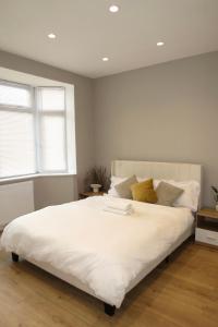 a bedroom with a large bed with white sheets at Luxury Flats - Hendon in Colindale