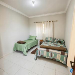 a bedroom with two beds and a window at Pousada Bem Estar Frutal in Frutal