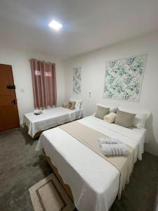 two beds in a room with white walls at Hotel Brisa Serrana no Centro de Serrinha in Serrinha +30 photos