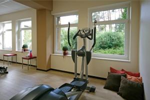 a gym with a treadmill in a room with windows at Boutique Hotel Azul in Möhnesee