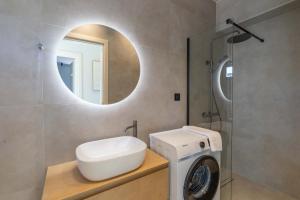 a bathroom with a washing machine and a mirror at Avelia Villa Tsoukalades in Tsoukalades