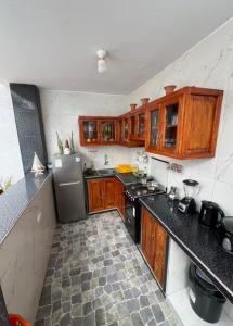 a kitchen with wooden cabinets and black counter tops at Mihahi Beach Mancora in Máncora +9 photos