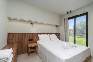 a bedroom with a large white bed and a window at Avelia Villa Tsoukalades in Tsoukalades