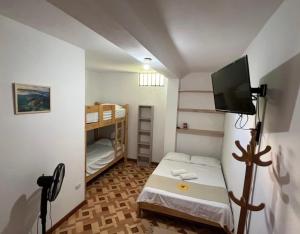 a small room with a small bed and a tv at Mihahi Beach Mancora in Máncora