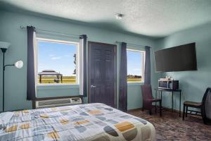 a bedroom with a bed and a flat screen tv at Clara City Inn in Clara City