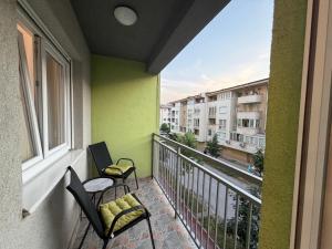a balcony with two chairs and a table and a building at Stan na dan Hilandarska 9 in Lukavica