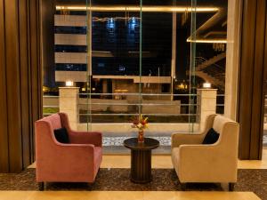 a lobby with two chairs and a table and a window at فندق فصل الصيف امان - المنسك in Abha