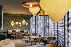 a dining room with tables and chairs and windows at Hotel Grand Brizo Buenos Aires in Buenos Aires