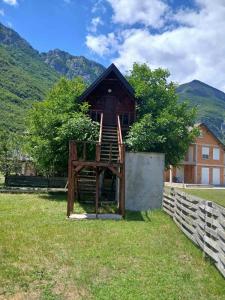 a tree house with a staircase in front of a building at TreeHouse Experience in Vusanje