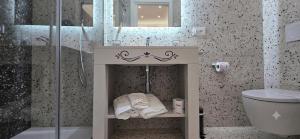 a bathroom with a shower and a toilet and towels at Salyn Apartments - The Heart of Tropea - Your Perfect Stay in Tropea