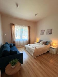 a bedroom with a bed and a blue couch at Hedera Home in Komárno