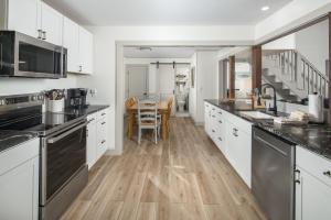 a kitchen with white cabinets and a wooden floor at Blue View Chalet in Blowing Rock +22 photos