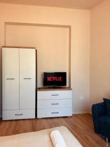 a bedroom with a white dresser with a tv on it at Hedera Home in Komárno