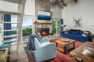 a living room with a blue couch and a fireplace at Blue View Chalet in Blowing Rock