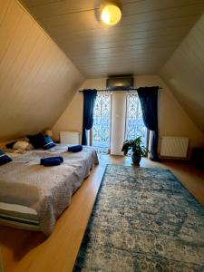 a attic bedroom with two beds and a rug at Piękna Góra in Giżycko