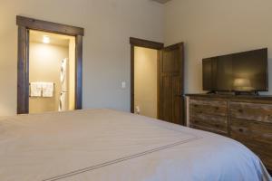 a bedroom with a bed and a flat screen tv at Cana Loft 301 in Whitefish