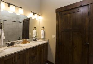 a bathroom with two sinks and a large mirror at Cana Loft 301 in Whitefish
