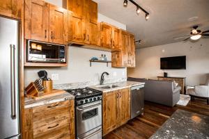 a kitchen with wooden cabinets and stainless steel appliances at Cana Loft 302 in Whitefish