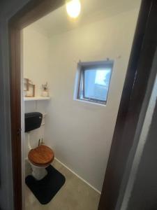 a bathroom with a toilet with a wooden toilet seat at Rondawel with sea view in Kleinmond +10 photos