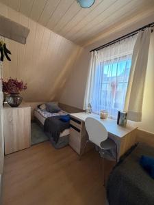 a room with a desk and a bed and a window at Piękna Góra in Giżycko
