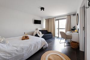 a bedroom with a white bed and a blue couch at Boutique Hotel Het Zoete Zijn in Borgloon