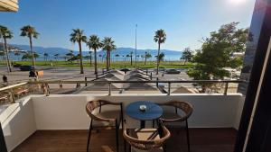 a balcony with two chairs and a table and a parking lot at Haris Hotel & Suites in Vlorë