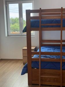 a bedroom with bunk beds and a window at Entre Mar e Vinhas RRAL Nº5668 in Biscoitos