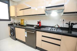 a kitchen with a sink and a stove at Résidence Acharif in Tan-Tan Plage
