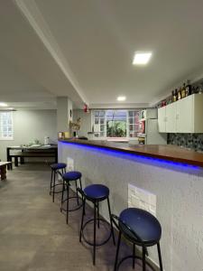 a bar with four blue stools in a room at Mobi Dicky in Nova Friburgo