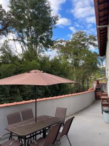 a table and chairs with an umbrella on a patio at Mobi Dicky in Nova Friburgo