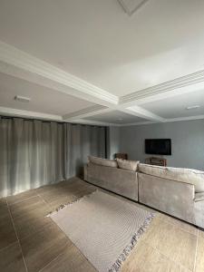 a living room with a couch and a flat screen tv at Mobi Dicky in Nova Friburgo