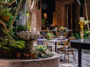 a patio with tables and chairs and a fountain at Hotel Casamada in San Miguel de Allende