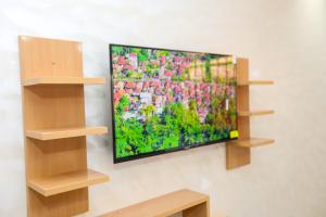 a flat screen tv hanging on a wall with shelves at Résidence Acharif in Tan-Tan Plage