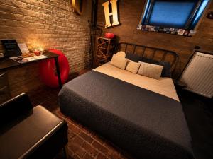 a bedroom with a bed in a brick wall at Les chambres atypiques de Nico Bush - Parking sécurisé vélos in Tournai +49 photos